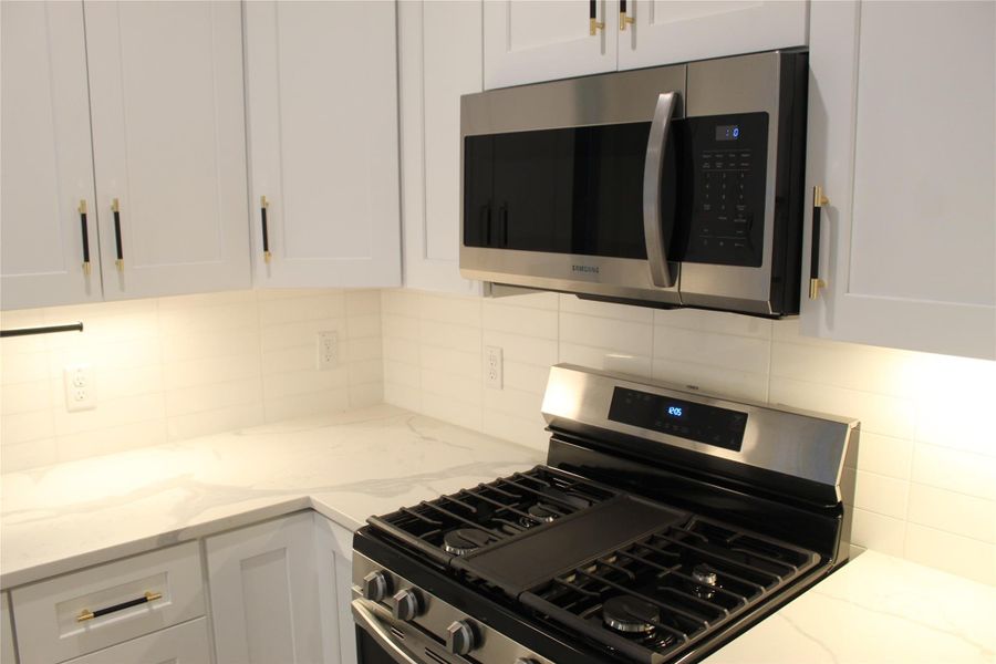 Culinary delights await in this modern kitchen with pristine counters and integrated appliances.
