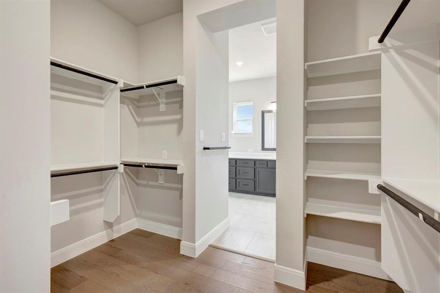 Walk in closet with light wood-style floors Walk in closet with light wood-style floors