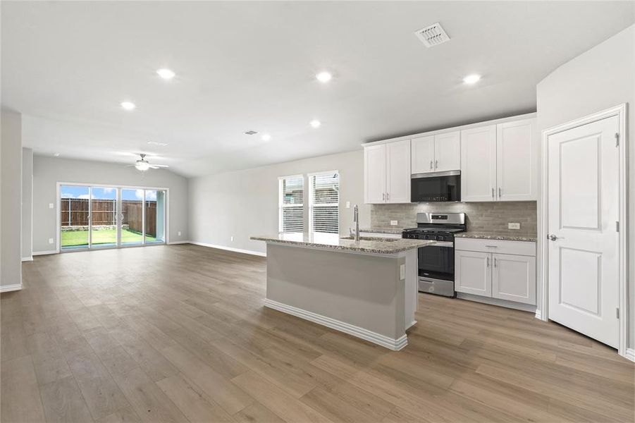 Kitchen with stainless steel appliances, backsplash, a ceiling fan, white cabinets, and recessed lighting Kitchen with stainless steel appliances, backsplash, a ceiling fan, white cabinets, and recessed lighting