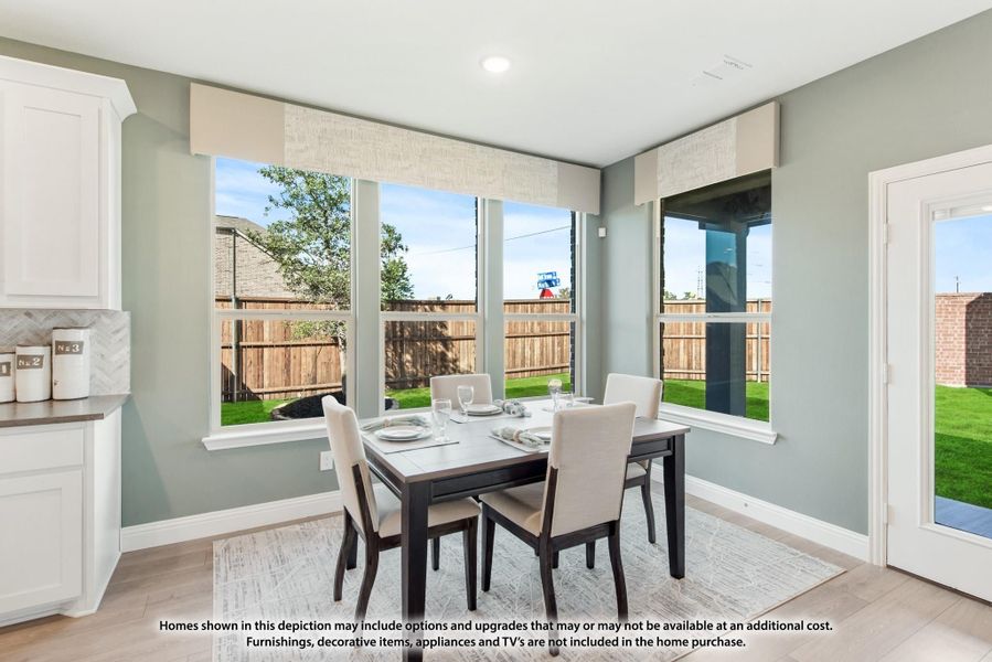 Dining area with dark wood table, four chairs, and large windows overlooking a fenced backyard Dining area with dark wood table, four chairs, and large windows overlooking a fenced backyard