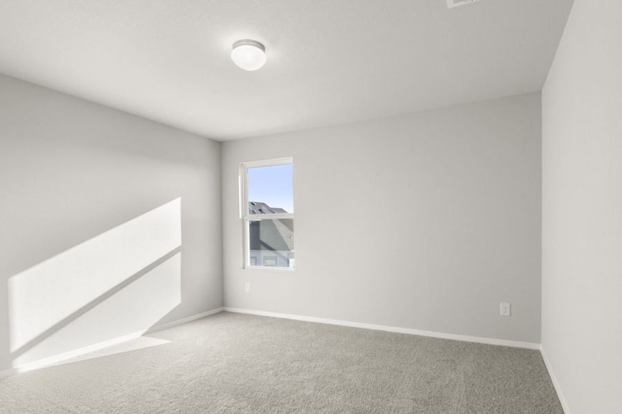Image of a bedroom with tan carpeting and light grey painted walls with a window in the corner Image of a bedroom with tan carpeting and light grey painted walls with a window in the corner