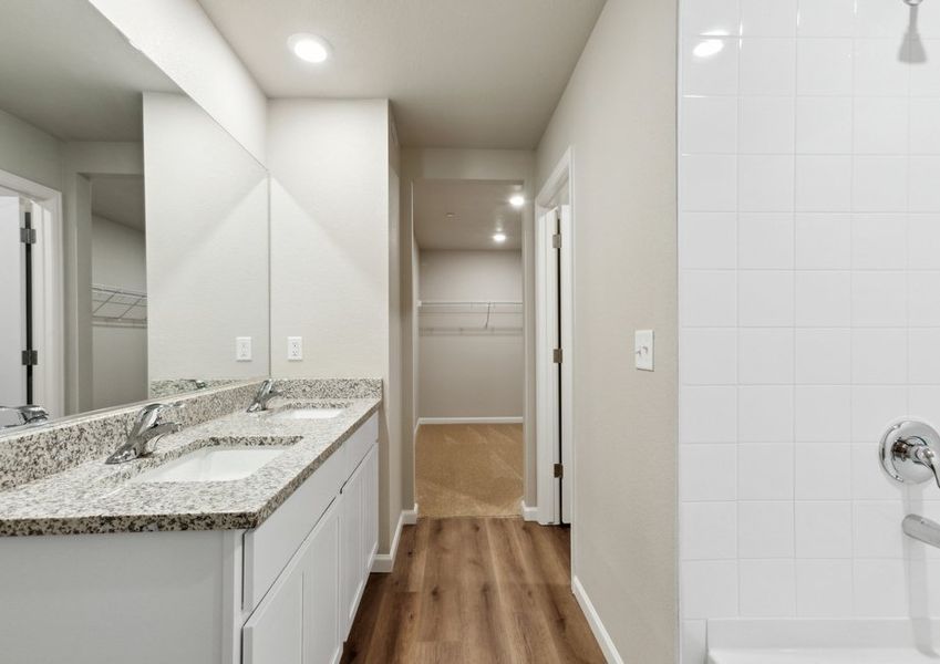 The master bathroom has a dual sink vanity and a soaking tub.