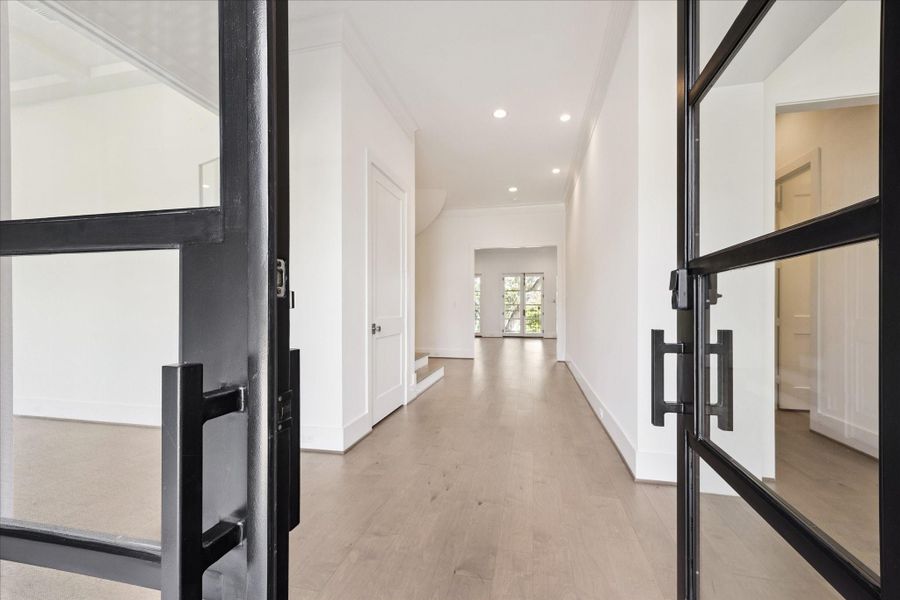 Spacious and light filled entry way with a home office to the left and dining room and butler's pantry to the right. Property enjoys wide plank wood flooring throughout, glass and iron front doors and an open foyer. Spacious and light filled entry way with a home office to the left and dining room and butler's pantry to the right. Property enjoys wide plank wood flooring throughout, glass and iron front doors and an open foyer.
