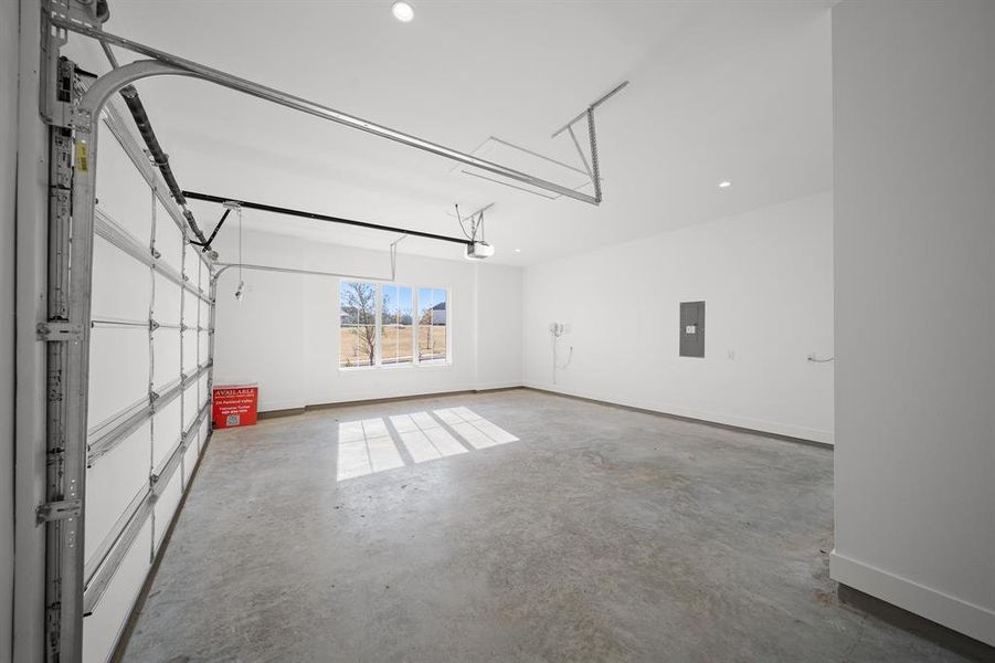 Garage featuring recessed lighting and electric panel