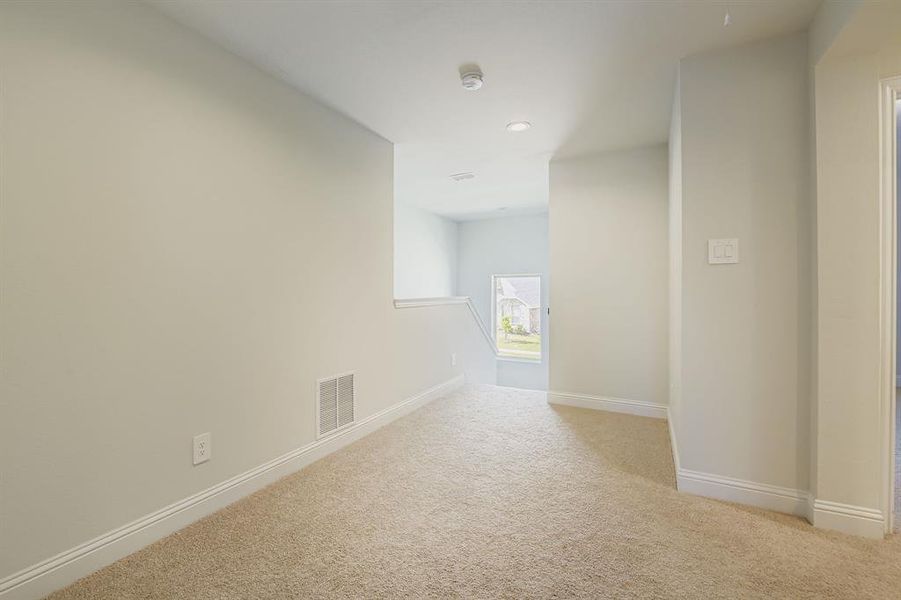Empty room with light colored carpet and recessed lighting Empty room with light colored carpet and recessed lighting