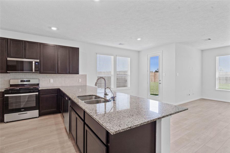 The focal point of the main living area, this expansive kitchen granite countertop which offers both ample prep space and a perfect breakfast bar.
