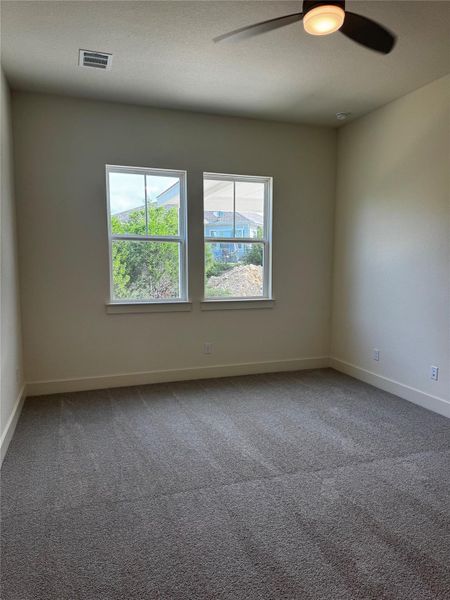 Spare room featuring carpet, a ceiling fan, and a textured ceiling Spare room featuring carpet, a ceiling fan, and a textured ceiling