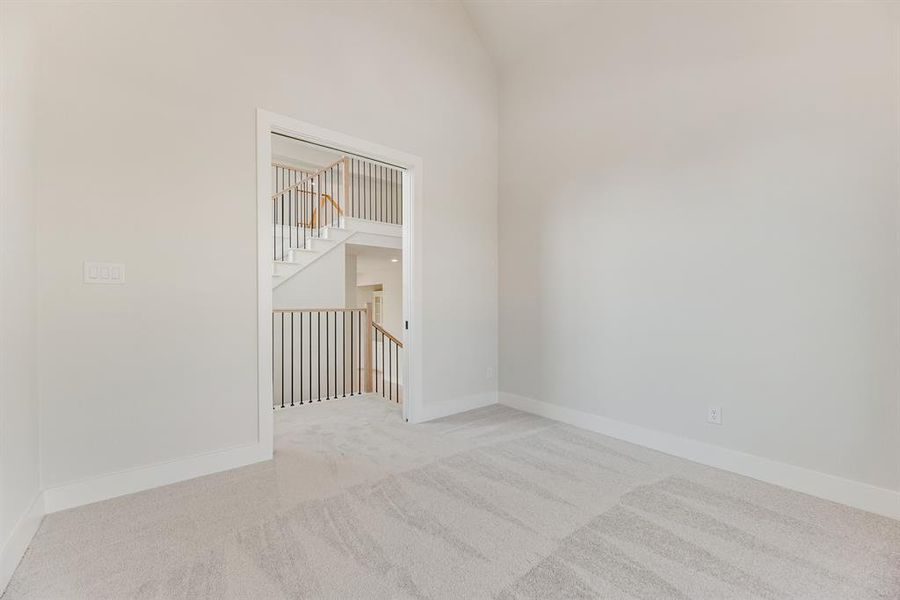 Spare room featuring light carpet and a towering ceiling Spare room featuring light carpet and a towering ceiling