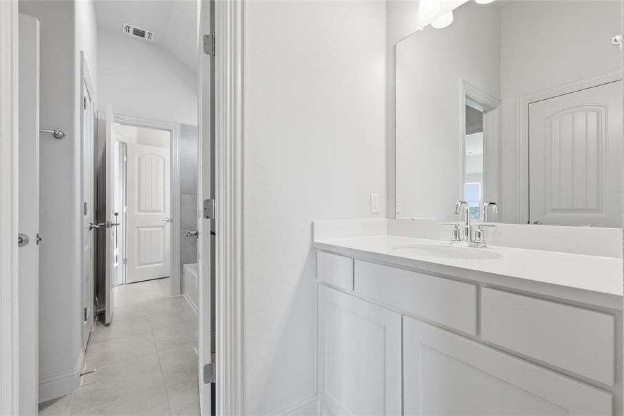 Bathroom with vanity, a tub, and light tile patterned floors