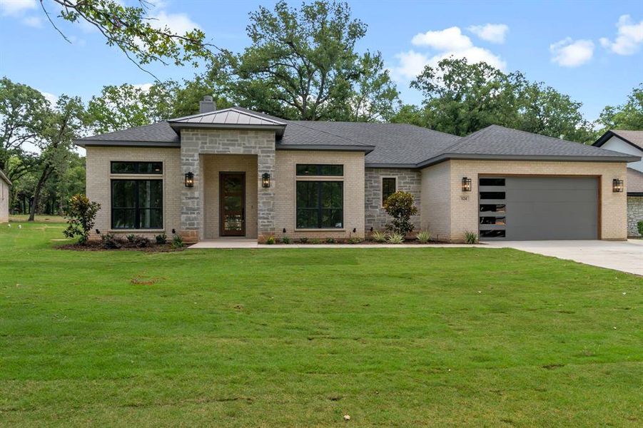 View of front of house featuring a garage and a front lawn