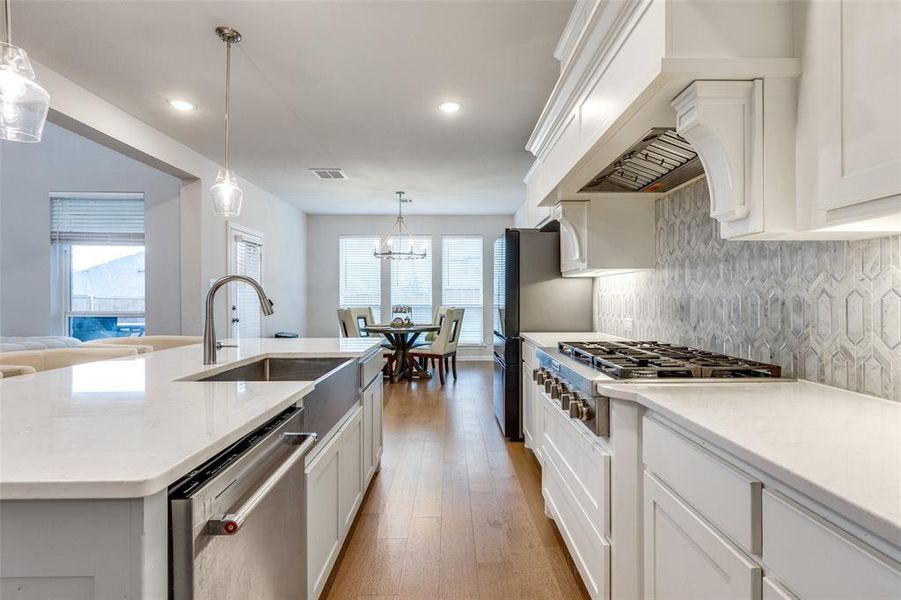 Kitchen with a center island with sink, plenty of natural light, stainless steel appliances, and light hardwood / wood-style flooring