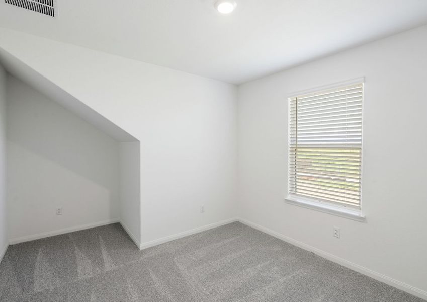 Secondary bedroom with lush carpet flooring