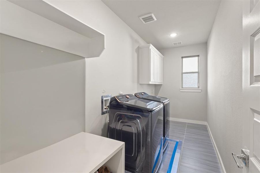 Washroom with washing machine and dryer, cabinet space, and recessed lighting