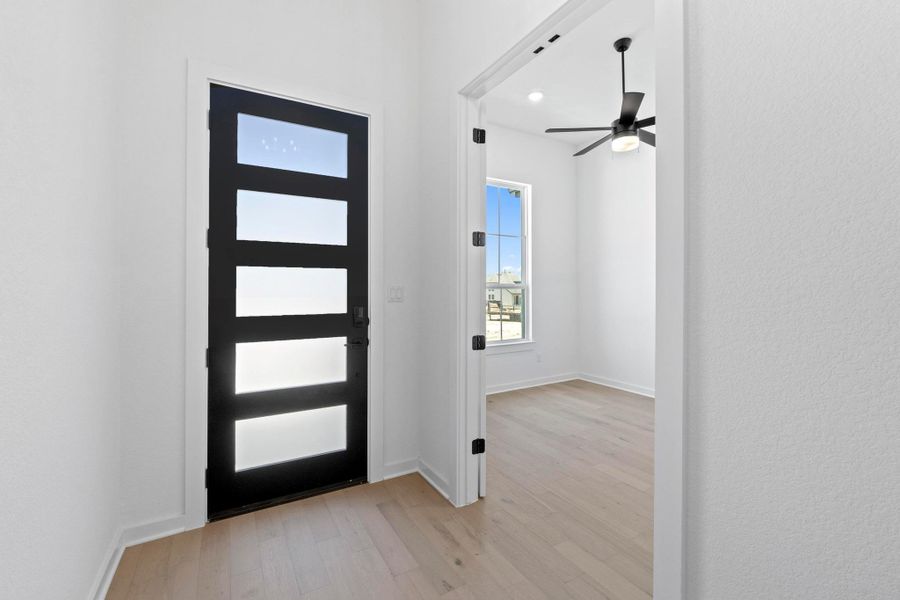 Foyer entrance featuring light wood finished floors and a ceiling fan