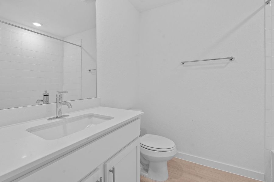 Bathroom featuring light wood-type flooring, vanity, and a shower