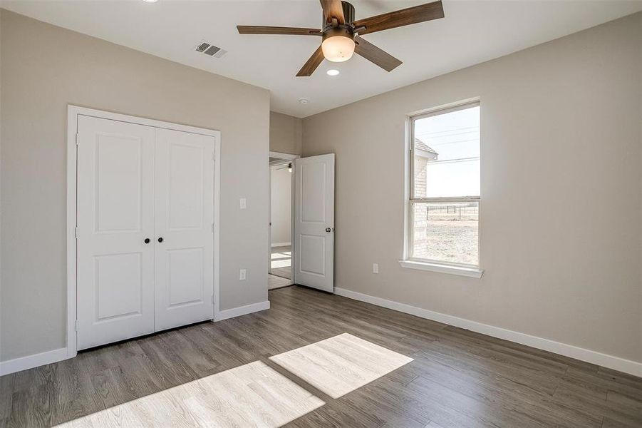 Unfurnished bedroom featuring ceiling fan, wood-type flooring, and a closet