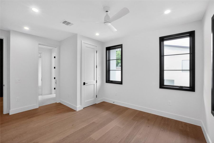 A well-lit room showcases rich hardwood flooring and modern fixtures throughout.