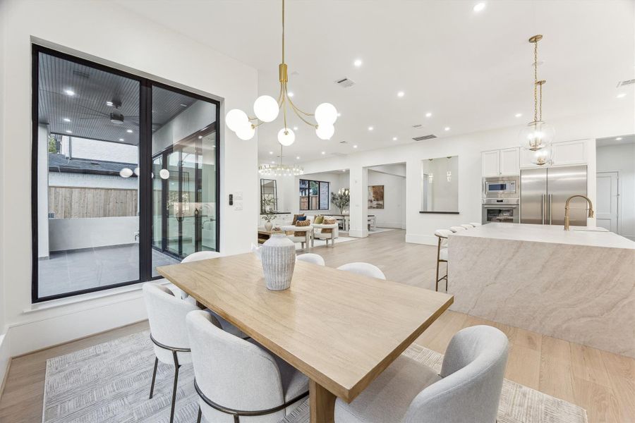 The breakfast area offers picturesque backyard views, accented by a charming chandelier
