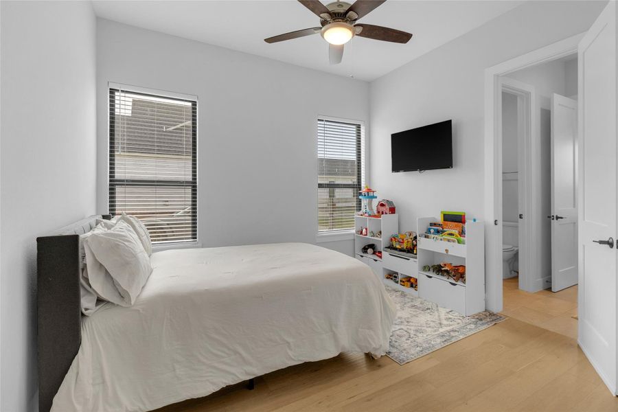 Bright secondary bedroom with large windows.