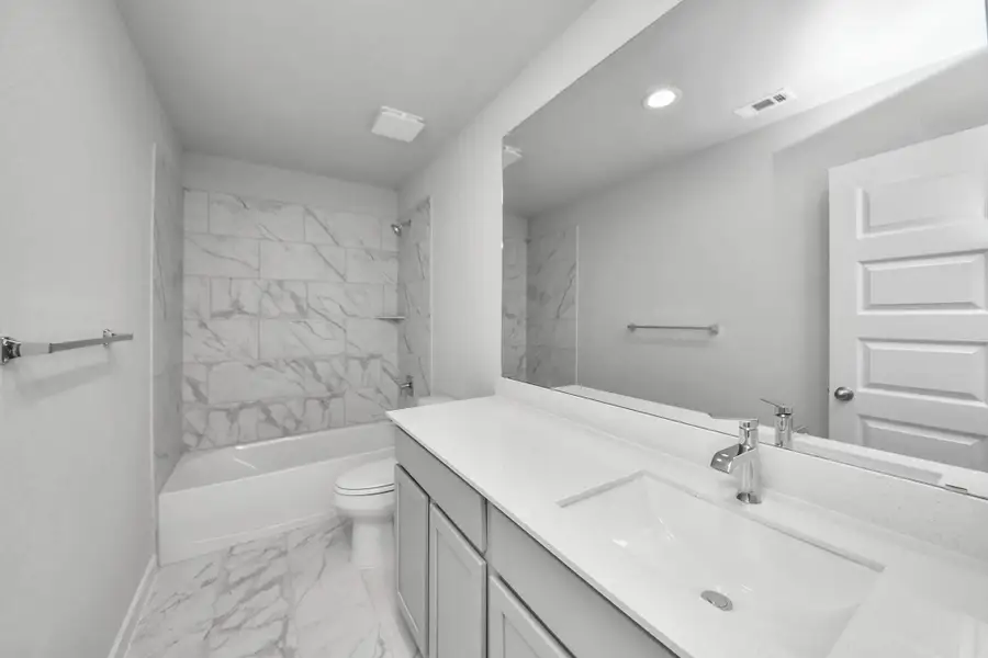 Secondary bath features tile flooring, bath/shower combo with tile surround, light stained wood cabinets, beautiful light countertop. Secondary bath features tile flooring, bath/shower combo with tile surround, light stained wood cabinets, beautiful light countertop.