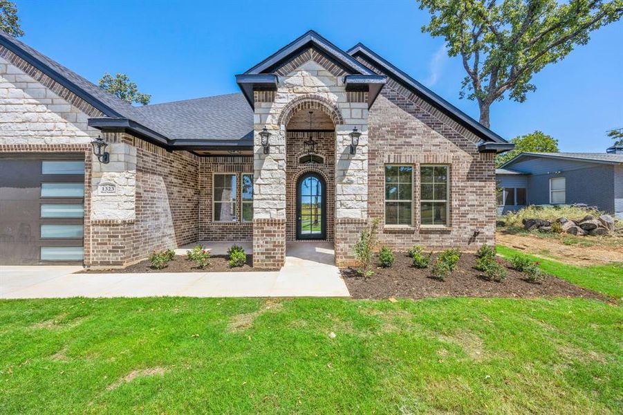 View of front of house with a garage and a front lawn