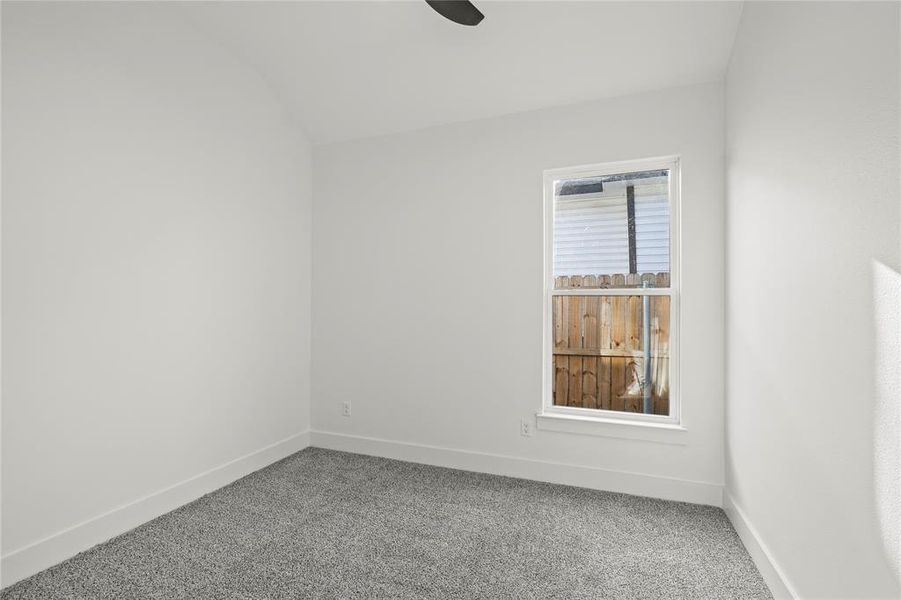 Unfurnished room with carpet and lofted ceiling