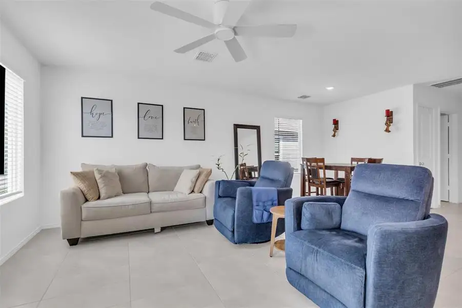 Living area with light tile patterned flooring and a ceiling fan