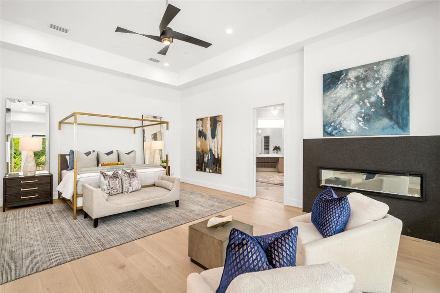 Retreat to the privately located first-floor primary suite, a serene haven featuring a cozy sitting area anchored by a sleek linear electric fireplace with a sophisticated leather-finish granite surround. Retreat to the privately located first-floor primary suite, a serene haven featuring a cozy sitting area anchored by a sleek linear electric fireplace with a sophisticated leather-finish granite surround.