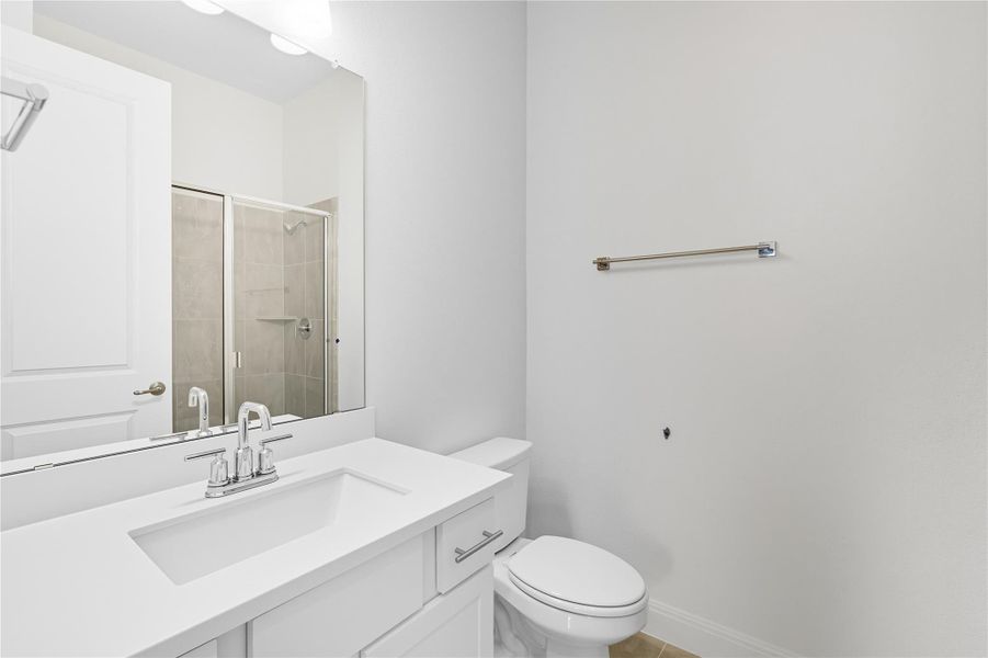 Bathroom with a shower stall, vanity, and light tile patterned floors