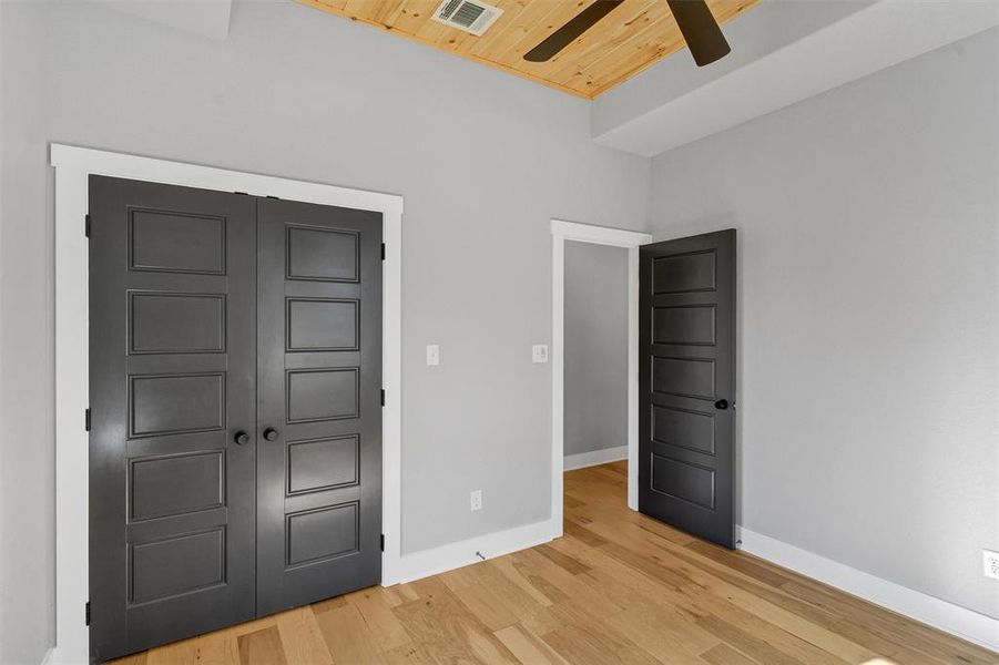 Unfurnished bedroom featuring wooden ceiling, a closet, light wood-type flooring, and ceiling fan Unfurnished bedroom featuring wooden ceiling, a closet, light wood-type flooring, and ceiling fan