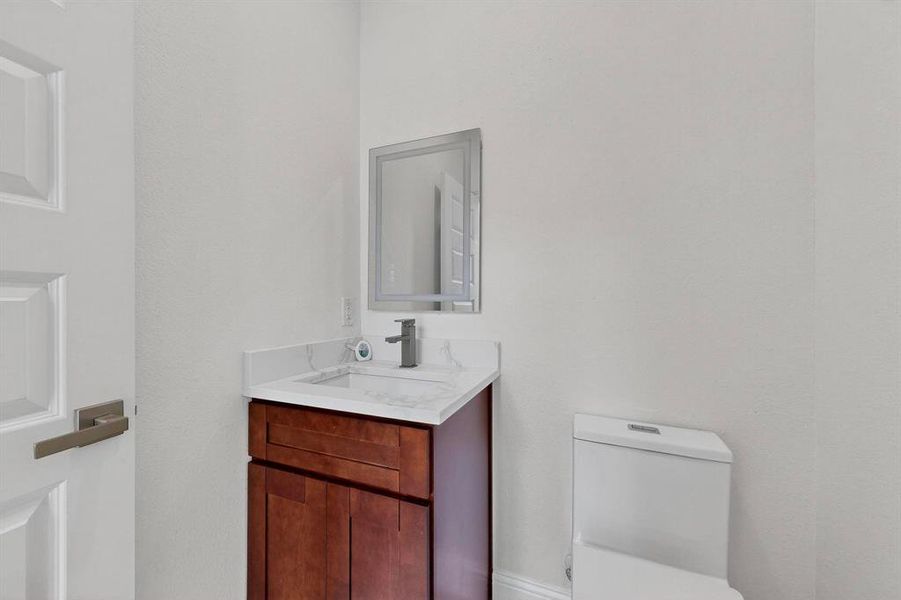 Half bathroom with vanity and toilet