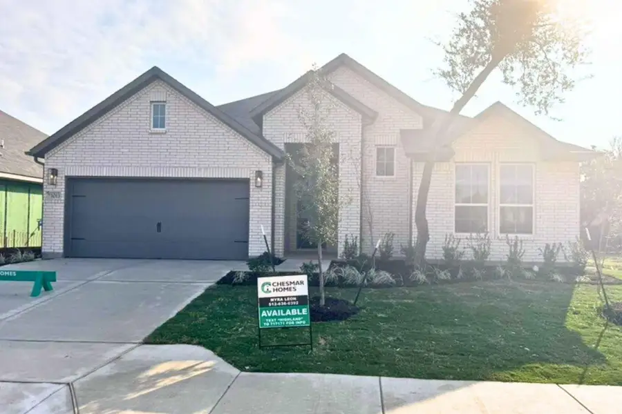 View of front of home with driveway, an attached garage, a front lawn, and brick siding View of front of home with driveway, an attached garage, a front lawn, and brick siding