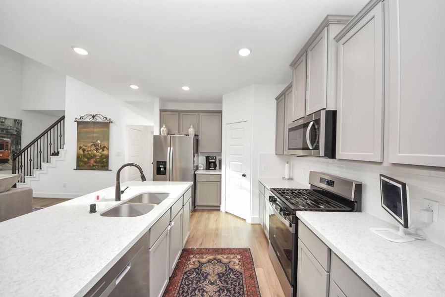 Another view of the contemporary kitchen with a large island, stainless appliances, and open-concept flow.