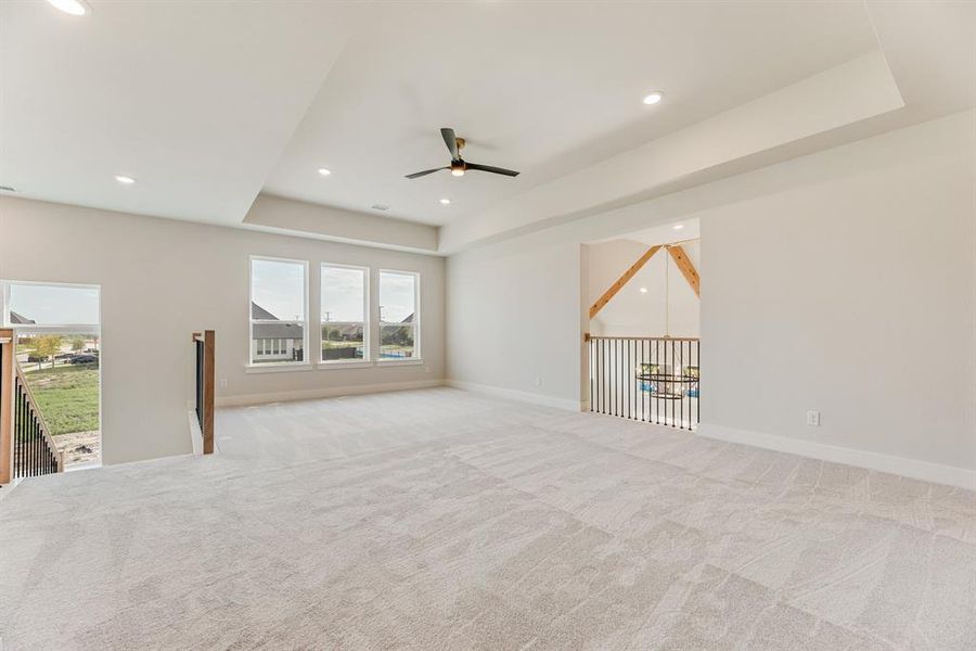 Carpeted spare room with a raised ceiling, recessed lighting, and a ceiling fan Carpeted spare room with a raised ceiling, recessed lighting, and a ceiling fan