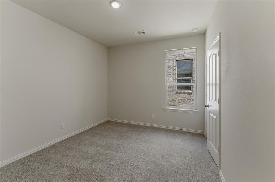 Neutral-toned room featuring a single window with exterior brickwork visible Neutral-toned room featuring a single window with exterior brickwork visible