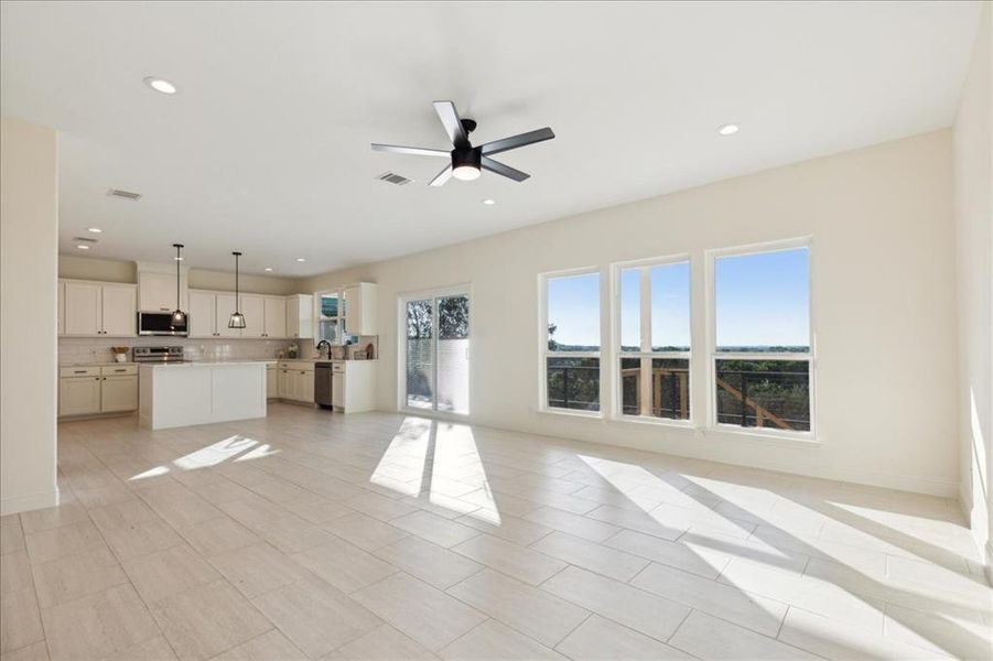 Unfurnished living room featuring ceiling fan