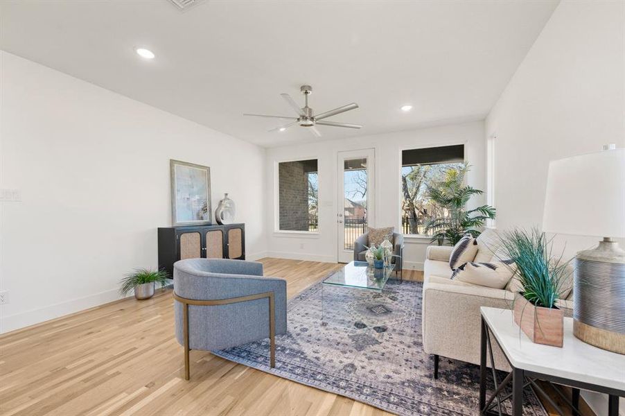 Living room with light wood-style flooring, ceiling fan, and recessed lighting
