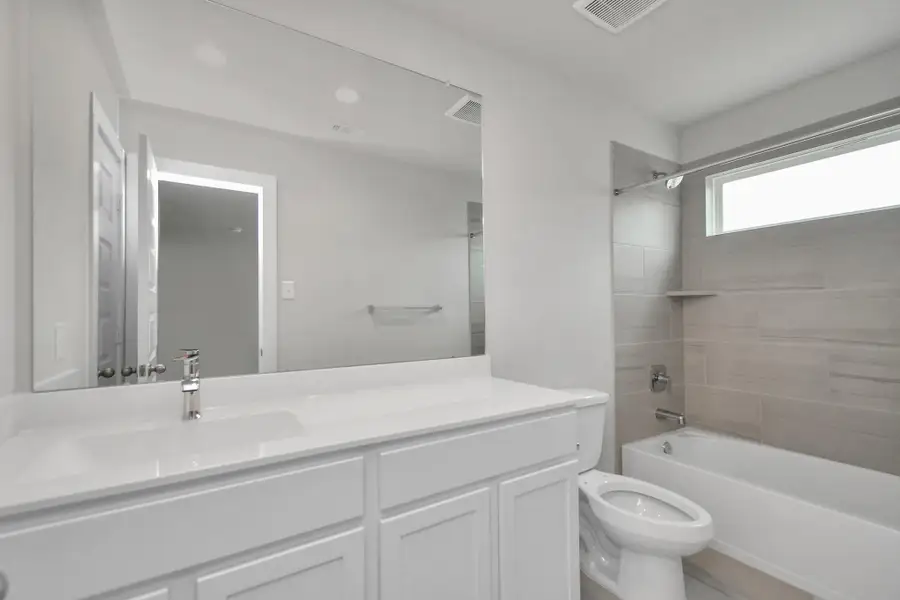 Bath/shower combo surrounded by tasteful tile in this secondary bath. Sample photo of completed home with similar floor plan. Actual colors and selections may vary.