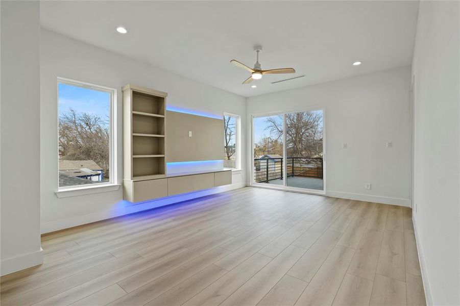 Unfurnished living room with light wood-type flooring, ceiling fan, plenty of natural light, and recessed lighting Unfurnished living room with light wood-type flooring, ceiling fan, plenty of natural light, and recessed lighting