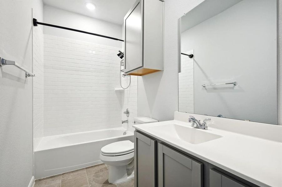 Full bathroom with vanity, toilet, and tiled shower / bath