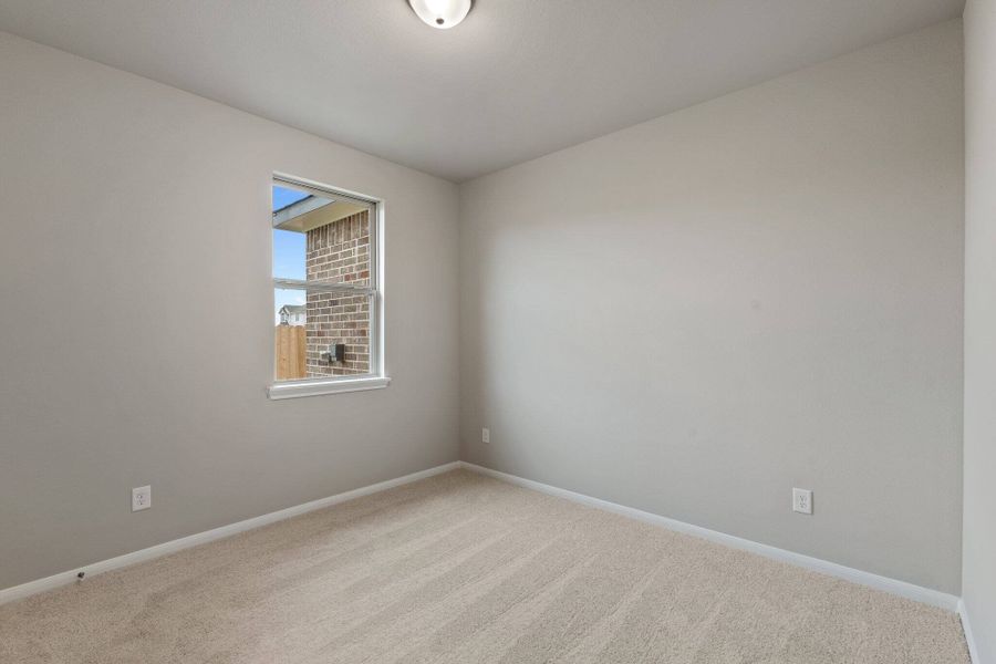 The fourth bedroom features plush carpet, fresh paint, closet, and a large window that lets in plenty of natural lighting with access to a private bath.