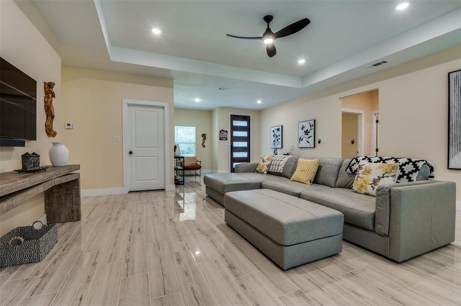 Living room featuring ceiling fan, recessed lighting, high polished tile floors and tray ceiling. Living room featuring ceiling fan, recessed lighting, high polished tile floors and tray ceiling.