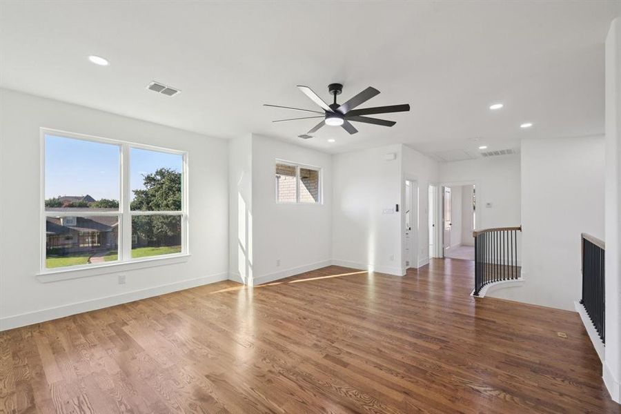 Unfurnished living room with attic access, wood finished floors, recessed lighting, and a ceiling fan