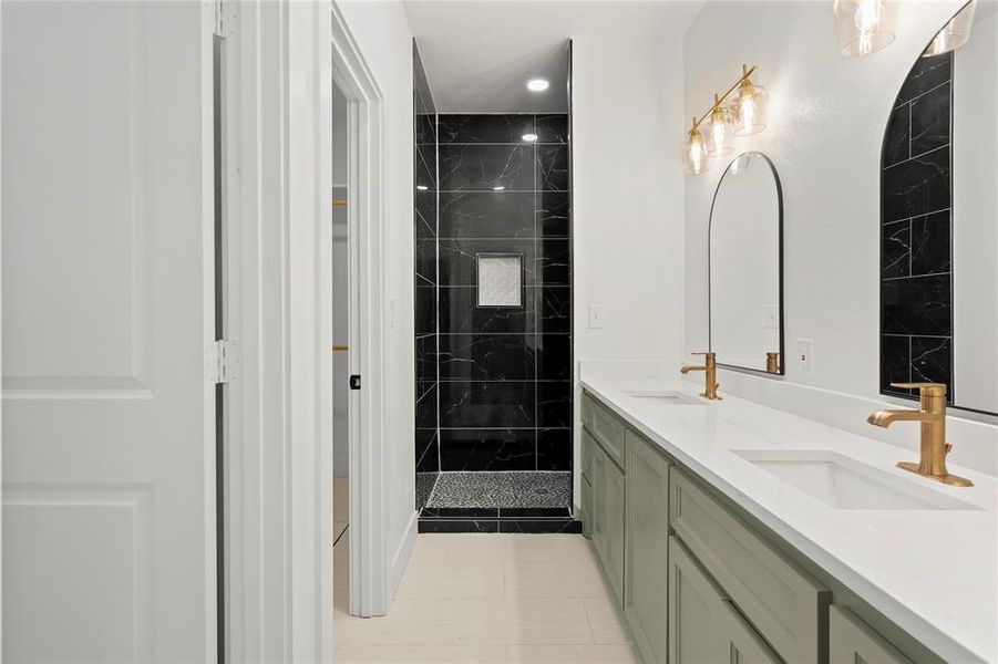 Bathroom featuring tile patterned flooring, vanity, and tiled shower