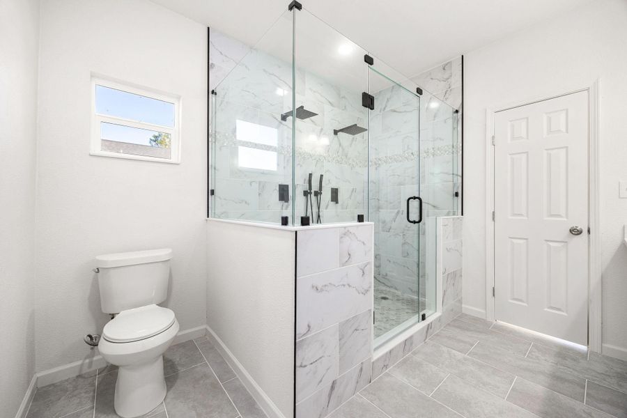 Luxurious primary bathroom featuring a spacious glass-enclosed shower, elegant marble tile, and modern fixtures. A serene retreat for relaxation. Luxurious primary bathroom featuring a spacious glass-enclosed shower, elegant marble tile, and modern fixtures. A serene retreat for relaxation.