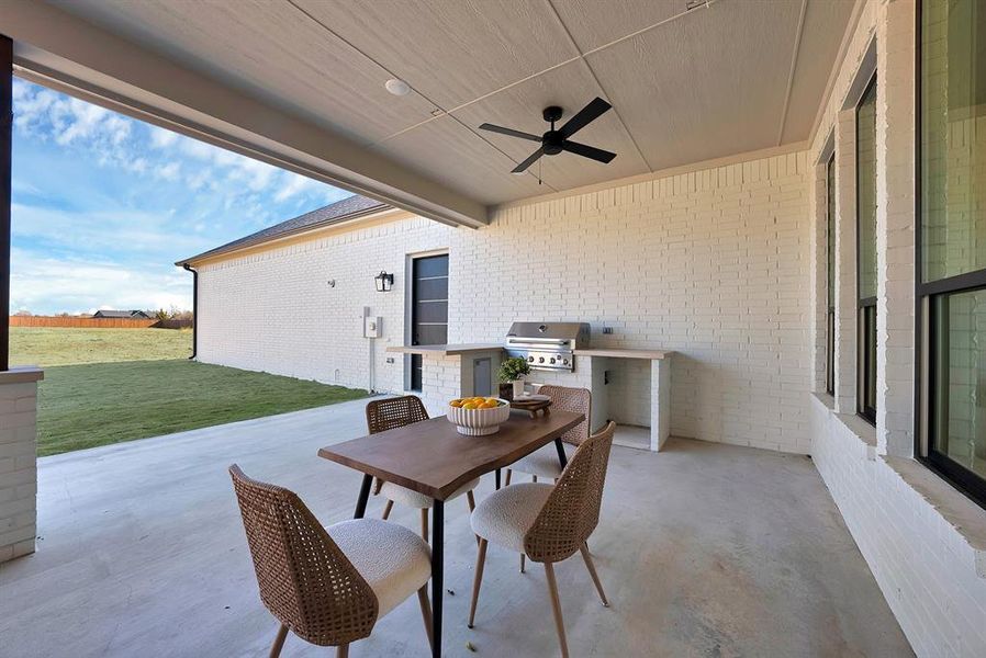 View of patio / terrace with ceiling fan, exterior kitchen, and outdoor dining area