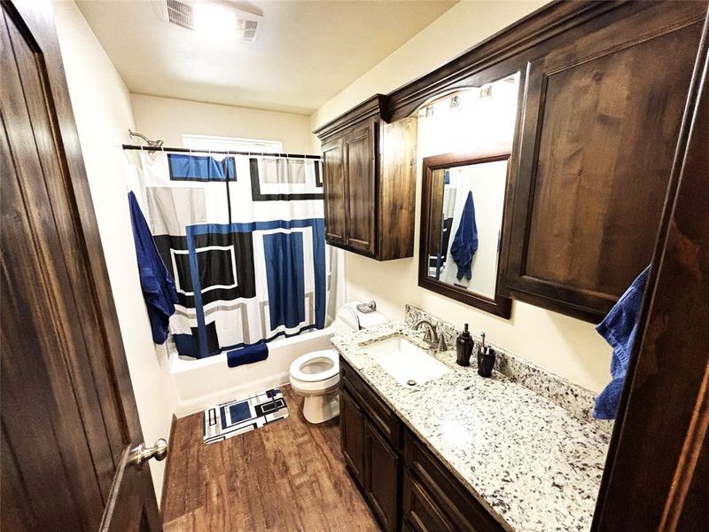 Bathroom with luxury vinyl plank flooring, shower / bathtub combination with curtain, and vanity Bathroom with luxury vinyl plank flooring, shower / bathtub combination with curtain, and vanity
