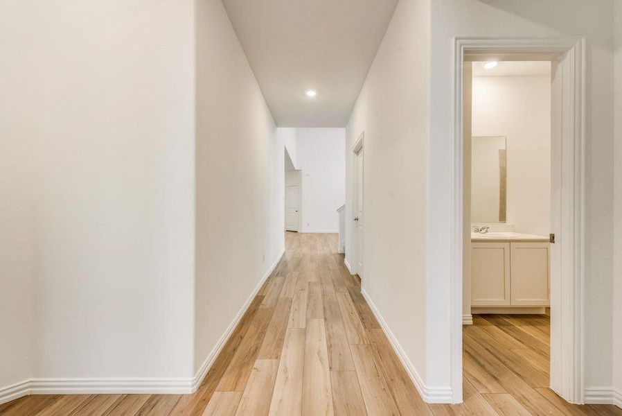 Hallway featuring sink and light wood-type flooring