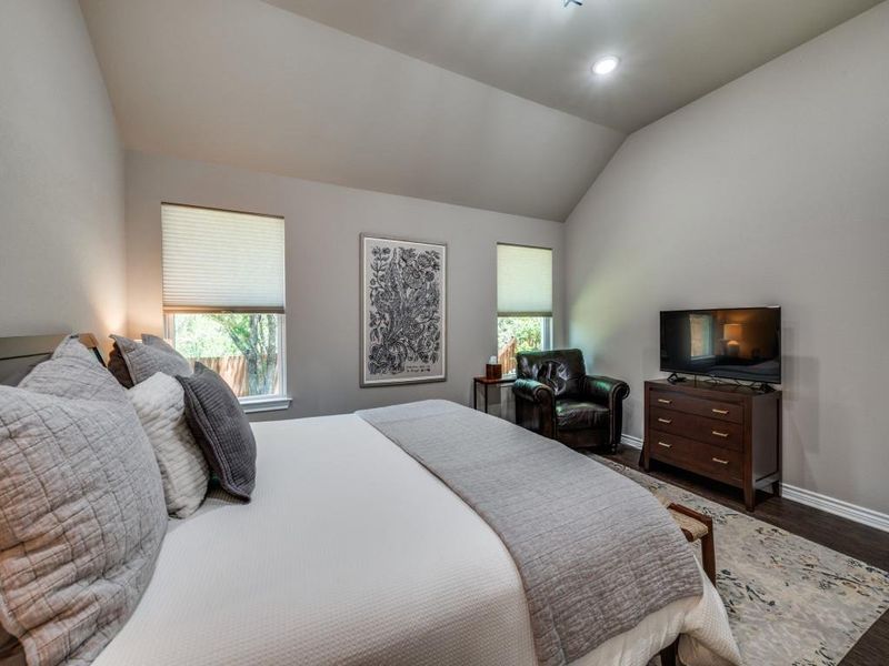 Bedroom with vaulted ceiling, baseboards, dark wood-style flooring, and recessed lighting Bedroom with vaulted ceiling, baseboards, dark wood-style flooring, and recessed lighting