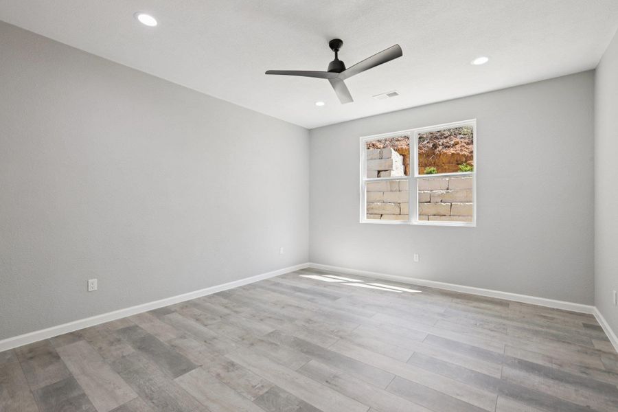 Primary Bedroom with a ceiling fan,light wood-type laminate flooring, and recessed lighting